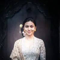 Ariel Tatum tampil memesona dengan kebaya putih dan kain batik sebagai selendang. Ia sempurnakan penampilannya dengan rambut yang disanggul dan diberi pemanis aksesori emas yang serasi. [Foto: Instagram/arieltatum]