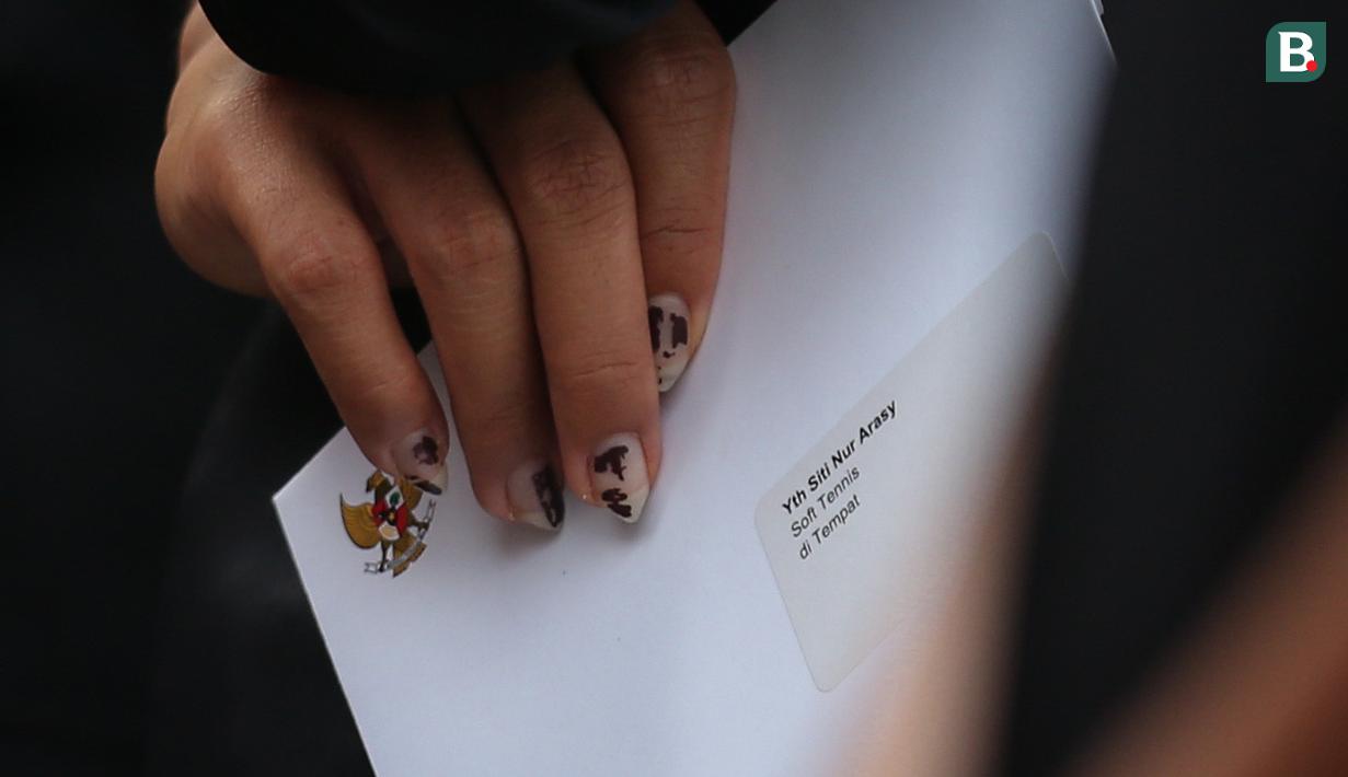 Atlet soft tennis Indonesia, Siti Nur Arasy memegang surat undangan saat pengukuhkan kontingen Indonesia untuk SEA Games 2023 Kamboja yang berlangsung di Kantor Kemenpora, Senayan, Jakarta, Selasa (02/05/2023). Sebanyak 599 atlet akan tampil dalam 31 cabang olahraga. (Bola.com/Bagaskara Lazuardi)