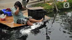 Warga mandi di Kali Cilemahabang yang menghitam di kawasan Karangbahagia, Kabupaten Bekasi, Jawa Barat, Selasa (7/9/2021). Warga memanfaatkan aliran Kali Cilemahabang yang menghitam dan mengeluarkan bau tak sedap untuk mencuci baju hingga mandi. (Liputan6.com/ Herman Zakharia)