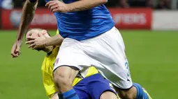 Pemain Italia, Giorgio Chiellini merebut bola dari pemain Swedia, Marcus Berg pada laga leg kedua playoff Piala Dunia 2018 di Stadion San Siro, Selasa (14/11). Swedia lolos ke Rusia 2018 berkat keunggulan agregat 1-0. (AP/Luca Bruno)