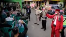 Petugas kepolisian berpakaian pejuang jaman dulu saat memberikan pengarahan kepada warga yang akan ikut vaksin Covid-19 di Polsek Pasar Rebo, Jakarta, Selasa (17/8/2021). Para petugas berkostum pejuang jaman dulu memeriahkan HUT ke-76 Republik Indonesia. (Liputan6.com/Angga Yuniar)