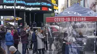 Orang-orang mengantre di tempat pengujian COVID-19 di Times Square, New York, Senin (13/12/2021). Wajib masker di semua tempat umum dalam ruangan di negara bagian New York mulai berlaku pada Senin ketika para pejabat menghadapi lonjakan kasus COVID-19 dan rawat inap. (AP Photo/Seth Wenig