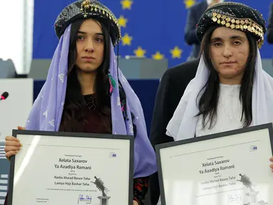 Nadia Murad basee Taha (kiri) dan Lamiya Aji Bashar, perempuan Yazidi yang diculik ISIS pada tahun 2014 dan dijadikan budak seks, menerima penghargaan Sakharov Prize 2016 di Parlemen Eropa di Strasbourg, Prancis, Selasa (13/12). (REUTERS/Vincent Kessler)