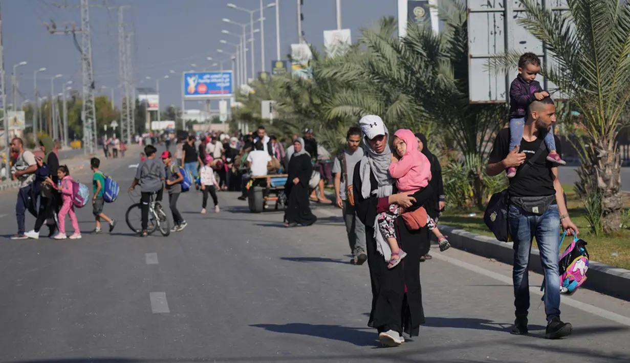 Warga sipil Gaza tersebut terlihat berjalan seraya mengibarkan bendera putih. (AP Photo/Hatem Moussa)