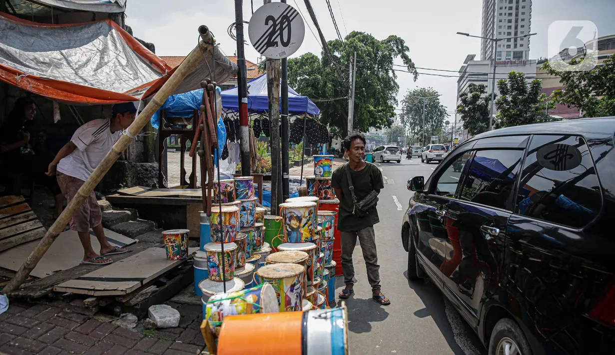 Pedagang bedug melayani pembeli di jalan KH Mas Mansyur, Tanah Abang, Jakarta, Senin (10/6/2021). Menjelang Idul Fitri 1442 H, pedagang bedug di sepanjang jalan itu mulai ramai menjajakan dagangannya dari harga 40 ribu - Rp 2,5 juta tergantung jenis, bahan dan ukuran. (Liputan6.com/Faizal Fanani)