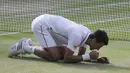 Setelah bertanding selama dua setengah jam, petenis Serbia itu meluapkan emosinya dengan berlutut dan makan sejumput rumput lapangan di depan 15.000 penonton, termasuk para selebriti, London, Minggu (6/7/14). (REUTERS/Suzanne Plunkett)