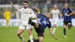 Pemain Inter Milan, Henrikh Mkhitaryan, berebut bola dengan pemain Benfica, Rafa Silva, pada laga Liga Champions di Stadion Giuseppe Meazza, Rabu (4/10/2023). Benfica awalnya memberi perlawanan sengit sepanjang babak pertama. Namun tiba-tiba mengendur begitu memasuki babak kedua. (AP Photo/Luca Bruno)