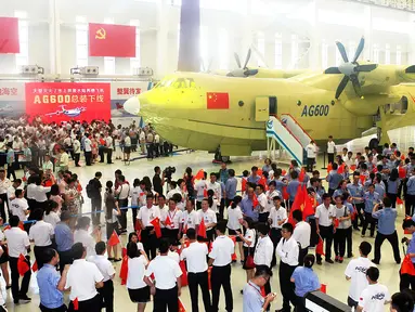 Sejumlah pekerja saat mengikuti peluncuran pesawat Amfibi AG600 di Zhuhai, Guangdong, China, (23/7). AG600 merupakan pesawat amfibi terbesar di dunia yang dibangun untuk misi maritim dan memadamkan kebakaran hutan. (AFP PHOTO/STR/Cina OUT)