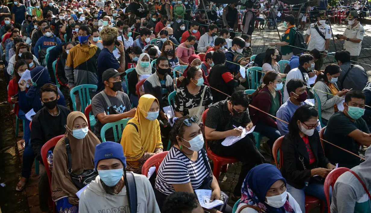 Warga menunggu dalam antrean untuk mendaftar vaksinasi virus corona COVID-19 AstraZeneca di Denpasar, Bali, Sabtu (26/6/2021). Ratusan warga terlihat antusias mengikuti vaksinasi massal tersebut. (SONY TUMBELAKA/AFP)