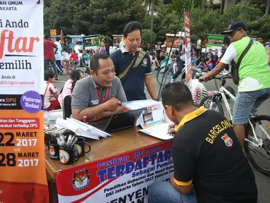 Seorang warga mengisi formulir pendaftaran di Pos Penyempurnaan Data dan Daftar Pemilih saat pelaksanaan Hari Bebas Kendaraan Bermotor (HBKB) di Jakarta, Minggu (12/3). (Liputan6.com/Immanuel Antonius)