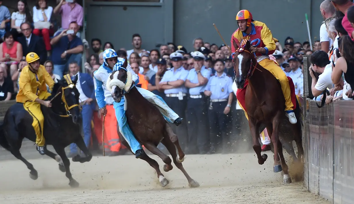 Para joki bersaing dalam balapan kuda Italia historis Palio di Siena, Italia (16/8). Perlombaan ini sudah digelar sejak abad pertengahan (sekitar tahun 1600-an) dan sampai sekarang tradisinya masih terus dipertahankan. (AFP Photo/Filippo Monteforte)
