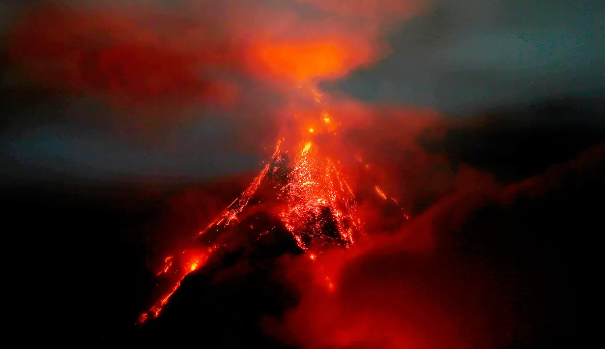 Batuan cair dan aliran lava menuruni lereng gunung berapi Mayon saat terjadi letusan ringan di Kota Legazpi, Provinsi Albay, tenggara Manila, Filipina, Sabtu (27/1). Meski memesona, letusan lava panas semakin berbahaya. (AP Photo/Bullit Marquez)