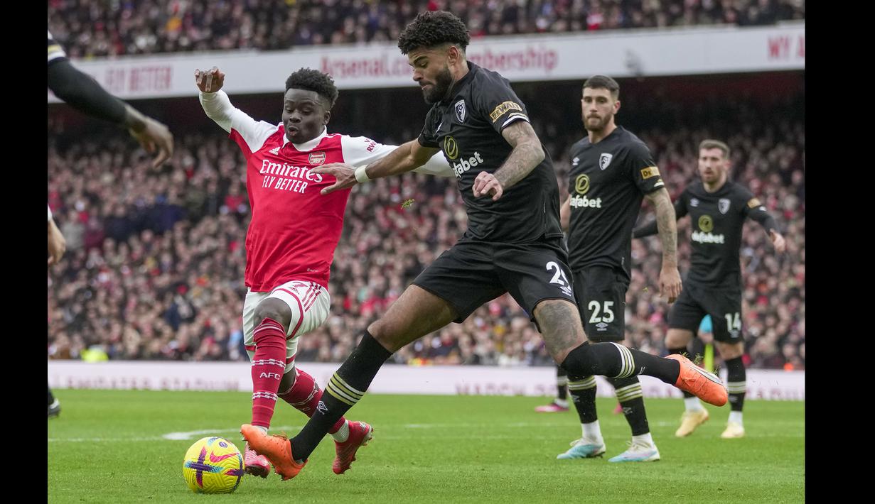 Pemain Bournemouth, Philip Billing (kanan) berebut bola dengan pemain Arsenal, Bukayo Saka pada laga pekan ke-26 Liga Inggris 2022/2023 yang berlangsung di Emirates Stadium, London, Sabtu (04/03/2023). (AP Photo/Kin Cheung)