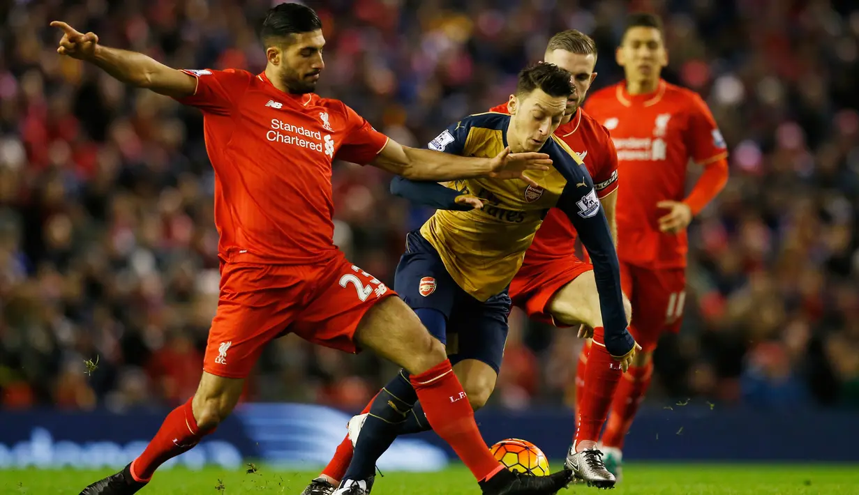 Gelandang Arsenal, Mesut Ozil berusaha melewati gelandang Liverpool, Emre Can pada pada lanjutan Liga Inggris di stadion Anfield, Inggris (14/1/2016). Liverpool bermain imbang dengan Arsenal dengan skor 3-3. (Reuters/Phil Noble)