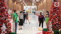 Pengunjung saat foto dengan dekorasi Natal di Grand Central Lippo Mall Puri, Jakarta, Minggu (5/12/2021). Dekorasi bertema  Classic Christmas dengan pohon natal yang dominan berwarna hijau dan merah serta berjajar nutracker menyambut pengunjung. (Liputan6.com/Fery Pradolo)