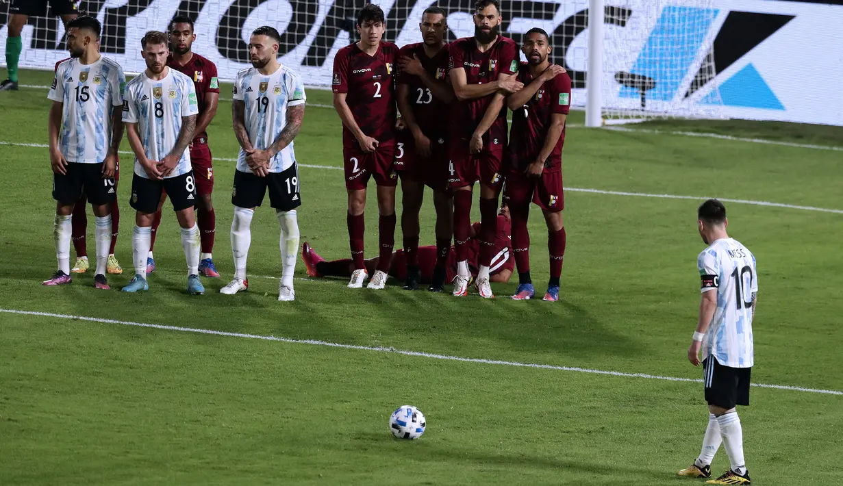 Pemain Argentina Lionel Messi (kanan) bersiap untuk tendangan bebas saat melawan Venezuela pada pertandingan sepak bola kualifikasi Piala Dunia 2022 di Stadion La Bombonera, Buenos Aires, Argentina, 25 Maret 2022. Argentina menang 3-0. (ALEJANDRO PAGNI/AFP)