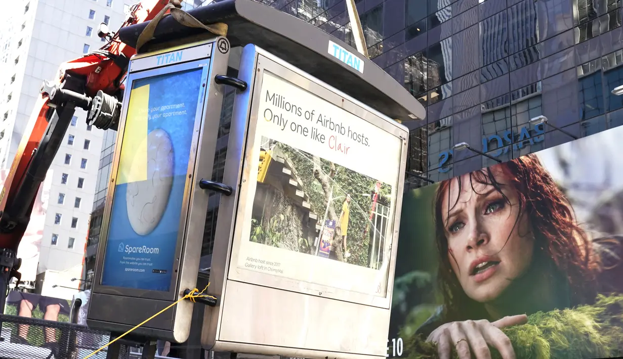 Para pekerja memindahkan bilik telepon umum terakhir NYC di dekat Seventh Avenue dan 50th Street di Midtown Manhattan, New York City, pada 23 Mei 2022. Telepon umum semakin ditinggalkan setelah pada 2015 Manhattan memasang ribuan hotspot yang menawarkan Wi-Fi gratis. (TIMOTHY A. CLARY / AFP)