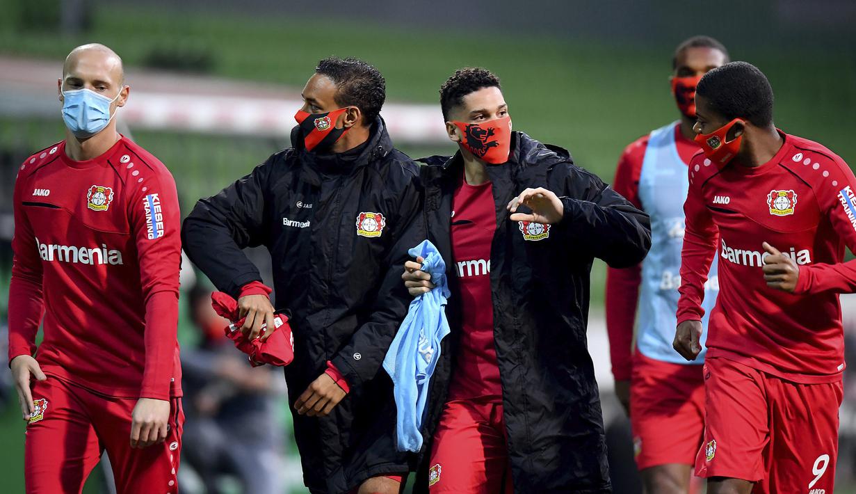 Pemain Bayer Leverkusen mengenakan masker saat istirahat babak pertama pada laga Bundesliga di Weserstadion, Bremen, Senin (18/5/2020). Bayer Leverkusen menang 4-1 atas Werder Bremen. (AP/Stuart Franklin)