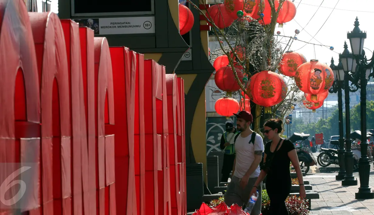 Dua WNA melintasi kawasan Ambarukmo Plaza, Yogyakarta yang di hiasi dengan Tulisan Gong Xi Fa Cai, Minggu (7/2). Hal ini untuk menarik perhatian masyarakat untuk berbelanja di mall tersebut.(Boy Harjanto)