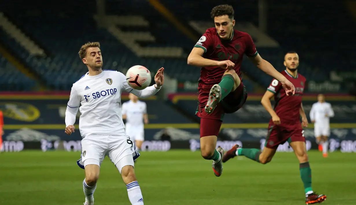 Bek Wolverhampton Wanderers, Max Kilman, berebut bola dengan striker Leeds United, Patrick Bamford, pada laga Liga Inggris di Elland Road, Selasa (20/10/2020) dini hari WIB. Wolves menang 1-0 atas Leeds United. (AFP/Alex Pantling/pool)