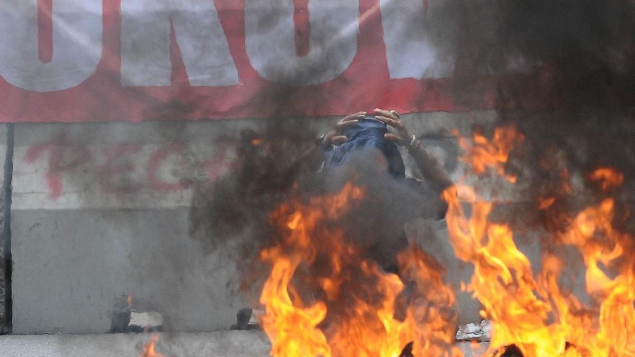 Pendemo melakukan aksi membakar ban saat protes di depan Kantor Komisi Pemilihan Umum (KPU), Jakarta, Senin (18/3/2024). Aksi demonstrasi ini dilakukan oleh sebagian besar pendukung pasangan calon presiden dan wakil presiden 01 dan 03. Foto: merdeka.com /