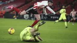 Gelandang Sheffield United, Oliver Burke dan bek Newcastle, Federico Fernandez berebut bola pada laga pekan ke-18 Liga Inggris di Bramall Lane, Rabu (13/1/2021) dini hari WIB. Sheffield memetik kemenangan perdana di Liga Inggris musim ini usai menang 1-0 atas Newcastle (Molly Darlington/Pool via AP)