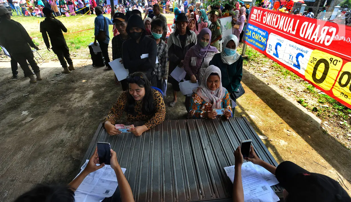 Petugas memfoto warga penerima manfaat saat penyaluran bantuan langsung tunai (BLT) Kemensos di Kecamatan Ciseeng, Bogor, Jawa Barat, Senin (28/11/2022). Setiap Keluarga Penerima Manfaat (KPM) mendapat BLT BBM sebesar Rp300ribu, Sembako Rp600 ribu dan bantuan PKH (Program Keluarga Harapan) sebesar Rp600 ribu. (merdeka.com/Arie Basuki)