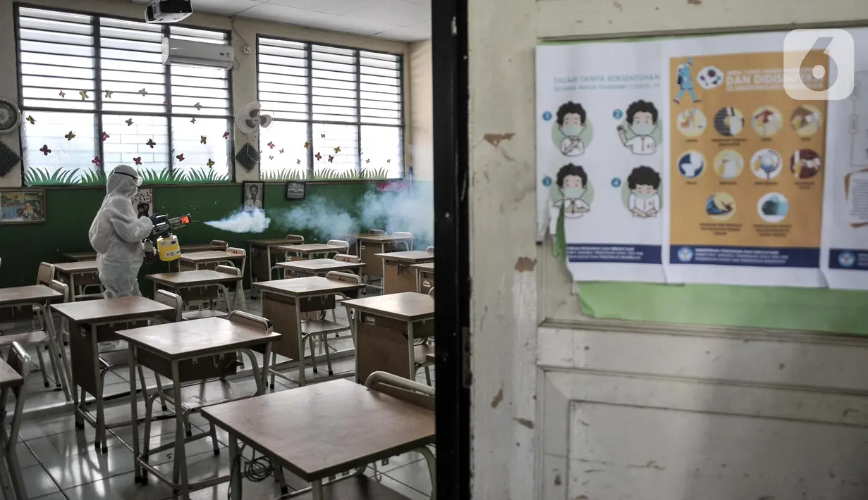 Petugas PMI menyemprotkan disinfektan sebagai upaya pencegahan COVID-19 di SDN Petojo Utara 01, Kecamatan Gambir, Jakarta, Kamis (3/2/2022). Pemerintah melalui Kemendikbud Ristek mengizinkan Pemprov DKI Jakarta menghentikan pelaksanaan PTM 100 persen menjadi 50 persen. (merdeka.com/Iqbal S. Nugroho)