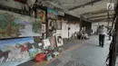 Seorang pria melihat karya lukisan di trotoar Kawasan Glodok, Jakarta, Selasa (15/5). Para pelukis ini menawarkan jasanya dengan kisaran harga Rp150 ribu sampai dengan Rp 5 juta. (Liputan6.com/Herman Zakharia)
