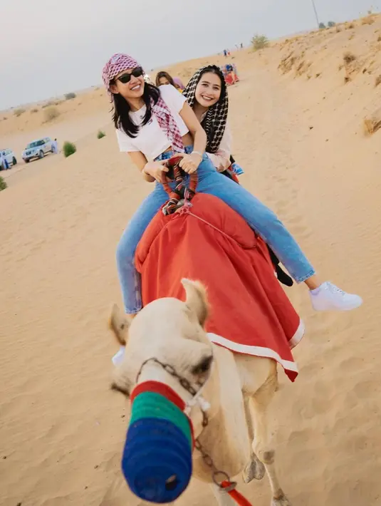 Bersama Shenina Cinnamon, Prilly Latuconsina menikmati serunya naik unta di gurun. Tentu sensasi merasakan unta di gurun akan berbeda saat berada di kebun binatang di Indonesia. Seperti menjadi musafir, momen kebersamaan keduanya ini terlihat mencuri perhatian. (Liputan6.com/IG/@prillylatuconsina96)