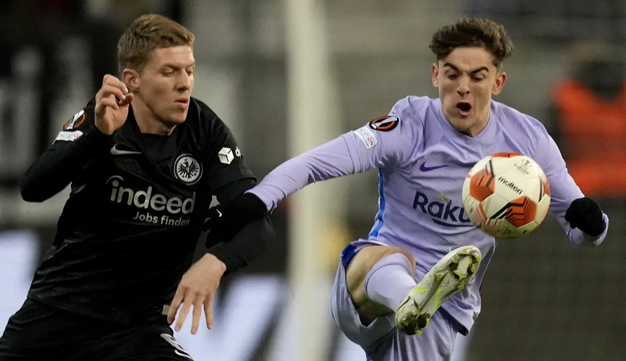 Gelandang Barcelona Gavi berebut bola dengan gelandang Eintracht Frankfurt Kristijan Jakic pada laga leg pertama perempat final Liga Europa 2021/22 di Deutsche Bank Park, Jumat dini hari WIB (8/4/2022). Frankfurt dan Barcelona berbagi skor 1-1 . (AP Photo/Michael Probst)