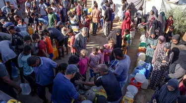 Warga pengungsi Palestina mengantre mengisi wadah mereka dengan air di Deir al-Balah, Jalur Gaza tengah pada 14 September 2024. (Bashar TALEB/AFP)