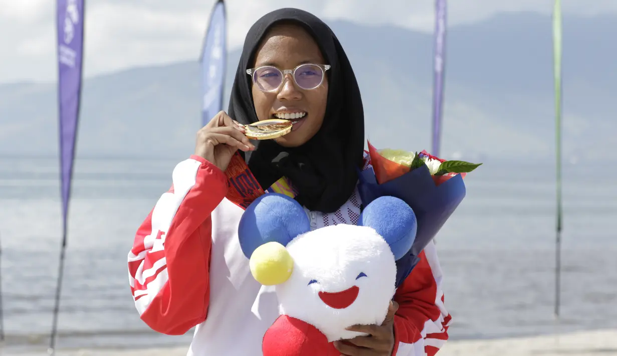 Atlet modern pentathlon, Dea Salsabila menunjukan medali usai meraih emas pada nomor beach triathle individual SEA Games 2019 di Subic, Jumat (6/12). Dirinya membukukan catatan waktu 00:19:52.73.  (Bola.com/M Iqbal Ichsan)