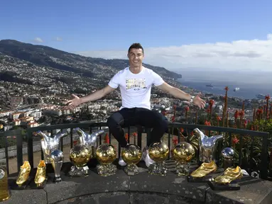 Bintang Real Madrid, Cristiano Ronaldo, berpose di depan trofi di kampung halamannya di Madeira, Portugal, Senin (1/1/2018). Pemain bernomor punggung tujuh itu memamerkan 15 trofi individual yang ia raih sebagai pemain terbaik. (AP/CR7 Media)