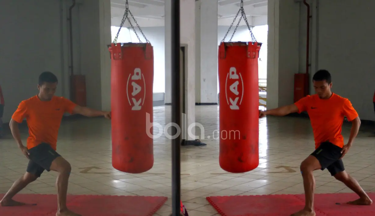Refleksi Cara seorang atlet Karateka putra Indonesia berlatih pukulan di Senayan Jakarta. (Bola.com/Nicklas Hanoatubun)