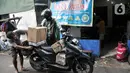 Pekerja menata produksi kue kering ke atas motor untuk diberikan kepada pelanggan di industri rumahan Pusaka Kwitang, Jakarta, Kamis (6/4/2023). (merdeka.com/Iqbal S Nugroho)
