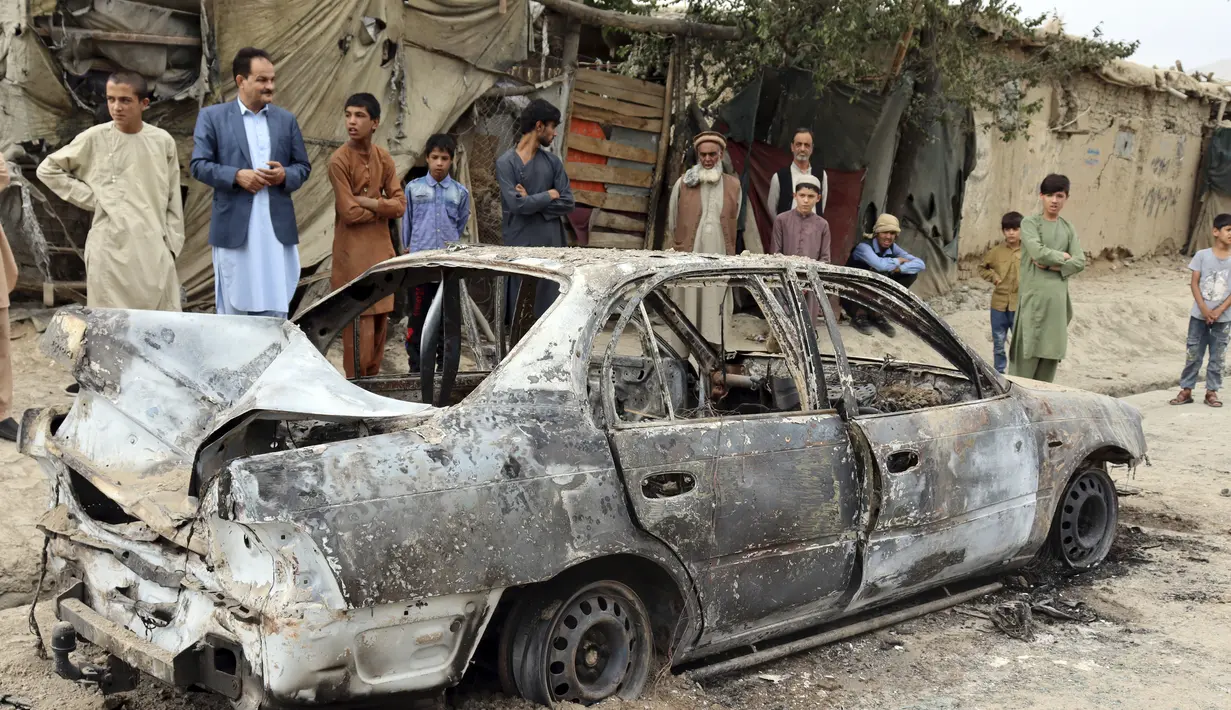 Penduduk setempat melihat kendaraan yang rusak akibat serangan roket di Kabul, Afghanistan, Senin (30/8/2021). Roket menghantam lingkungan dekat bandara internasional Kabul pada hari Senin di tengah penarikan AS yang sedang berlangsung dari Afghanistan. (AP Photo/Khwaja Tawfiq Sediqi)