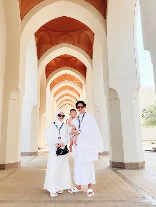 Tak hanya berdua, Dinda Hauw dan Rey Mbayang  juga ikut membawa putra pertamanya, Arshakalif Muhammad Mbayang. Ibu satu anak itu tampil anggun mengenakan gamis berwarna putih. Sementara Rey Mbayang juga terlihat memakai kain ihram berwarna senada dengan pakaian sang istri. (instagram.com/dindahw)