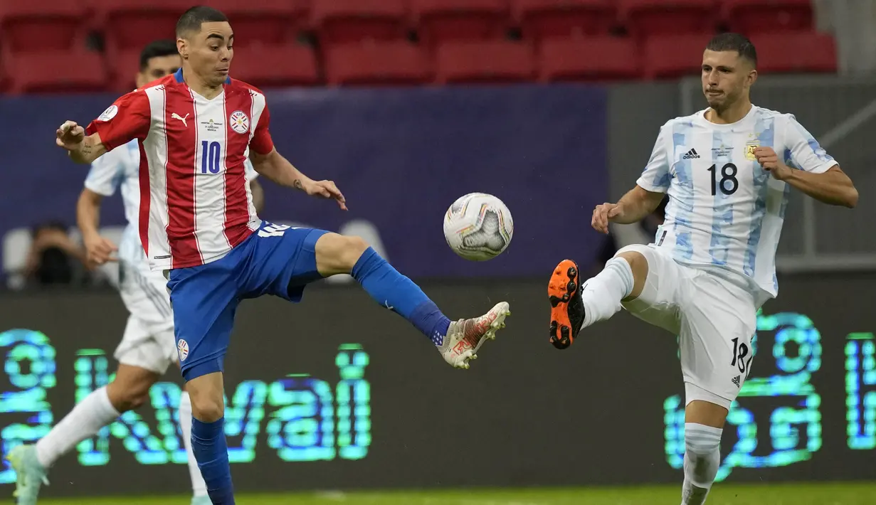 Gelandang Paraguay, Miguel Almiron berebut bola dengan gelandang Argentina, Guido Rodriguez pada pertandingan partai matchday 3 Grup A Copa America 2021 di Stadion Nasional, Brasil, Selasa (22/6/2021). Argentina menang tipis atas Paraguay 1-0 berkat gol tunggal Gomez. (AP Photo/Ricardo Mazalan)