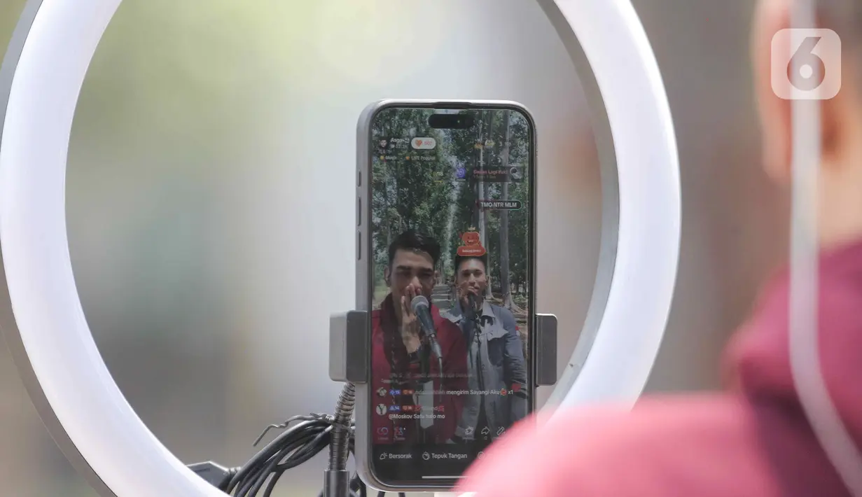 Para Tiktokers menampilkan bakat menyanyinya lewat "live streaming" di TikTok dengan latar belakang pepohonan hijau di Kawasan KBT. (Liputan6.com/Herman Zakharia)