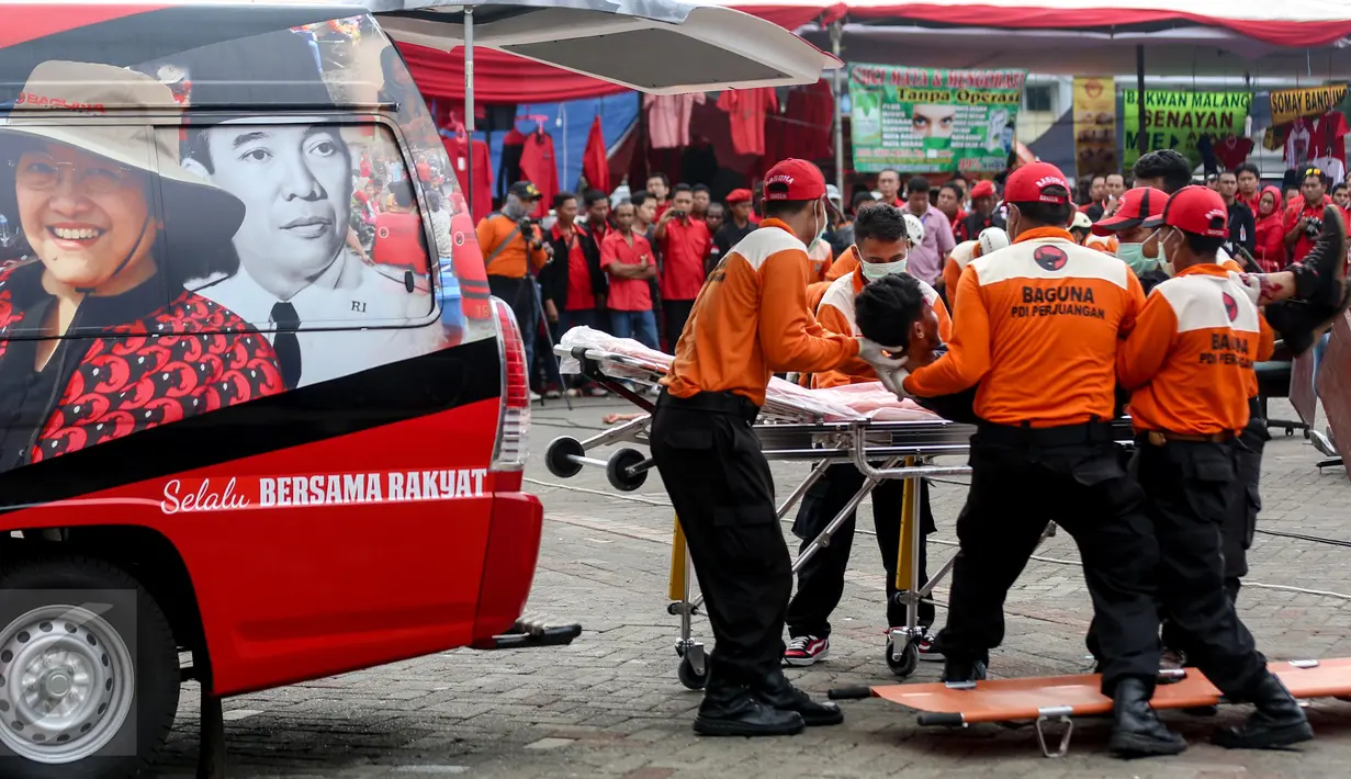 Sejumlah anggota Badan Penanggulangan Bencana (Baguna) PDI Perjuangan mengevakuasi korban saat latihan seusai penutupan Rakernas I PDI-Perjuangan di Jakarta, Selasa (12/1). (Liputan6.com/Faizal Fanani)