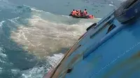 Petugas penyelamat mengevakuasi korban KM Lestari Maju yang tenggelam di lepas pantai Pulau Selayar, Provinsi Sulawesi Selatan, Selasa (3/7). Proses evakuasi korban tenggelamnya KM Lestari Maju masih berlangsung. (BNPB/AFP)