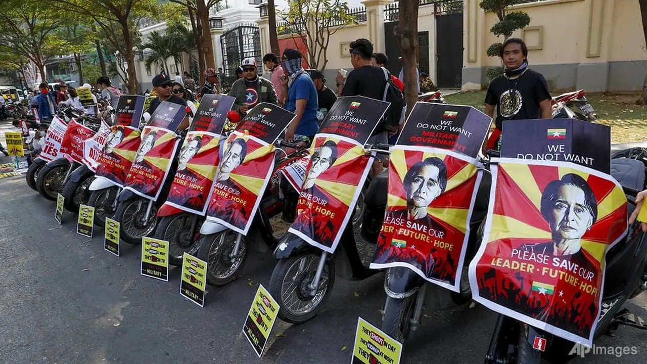 Penggemar sepak bola Klub Sepak Bola Arsenal memajang plakat menentang kudeta militer dengan sepeda motor mereka di Mandalay, Myanmar pada 18 Februari 2021. (Foto AP)