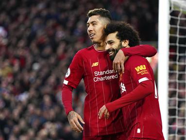 Pemain Liverpool, Mohamed Salah dan Roberto Firmino merayakan gol yang dicetak ke gawang Southampton pada laga Premier League di Stadion Anfield, Sabtu (1/2/2020). Liverpool menang 4-0 atas Southampton. (AP/Jon Super)