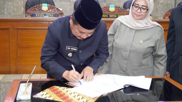 Disaksikan Ketua DPRD Garut Euis Ida Wartiah, Bupati Garut Rudy Gunawan, tengah menandatangani dokumen sidang paripurna persiapan pembentukan DOB Garut Selatan