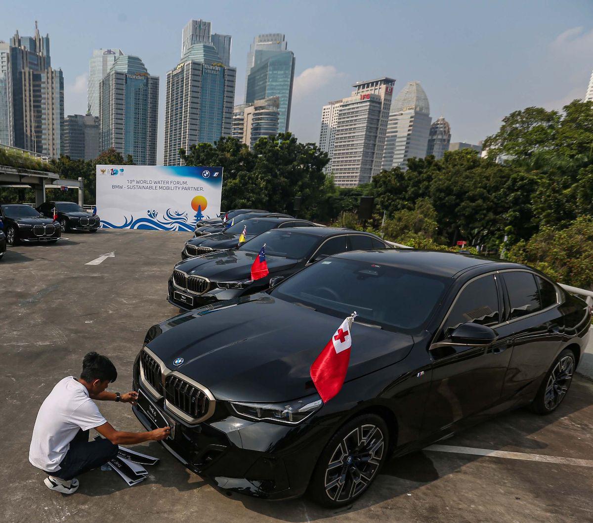 Petugas membersihkan mobil BMW i7 dan i5 di kompleks Gelora Bung Karno (GBK), Senayan, Jakarta, Jumat (3/5/2024).&nbsp;BMW Group Indonesia menyerahkan 51 unit mobil listrik mewah kepada Kementerian Sekretariat Negara.&nbsp;Foto: Liputan6.com/Angga Yuniar