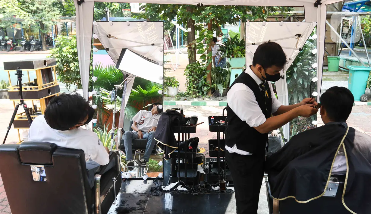 <p>Petugas memangkas rambut pelajar di SMA Negeri 70 Jakarta, Kamis (25/5/2023). (Liputan6.com/Herman Zakharia)</p>