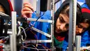 Ekspresi salah satu anggota, Liza Azizi saat memperbaiki masalah pada robot sebelum pembukaan The First Global Challenge di Washington, AS, Minggu (16/7). Bagi mereka, tahun ini adalah kompetisi tahunan robotik untuk pertama kalinya. (AP/Cliff Owen)
