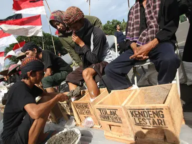 Petani Kendeng berunjuk rasa memasung kaki dengan semen di depan Istana Negara, Jakarta, Rabu (15/3). Unjuk rasa mereka telah memasuki hari ketiga. (Liputan6.com/Immanuel Antonius)