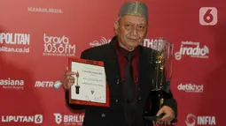 Sinematografer H.M. Soleh Ruslani berpose memegang piala saat menerima Anugerah Festival Film Indonesia (FFI) 2023 kategori  Pengabdian Seumur Hidup di Ciputra Artpreneur, Jakarta, Selasa (14/11/2023). (Liputan6.com/Herman Zakharia)